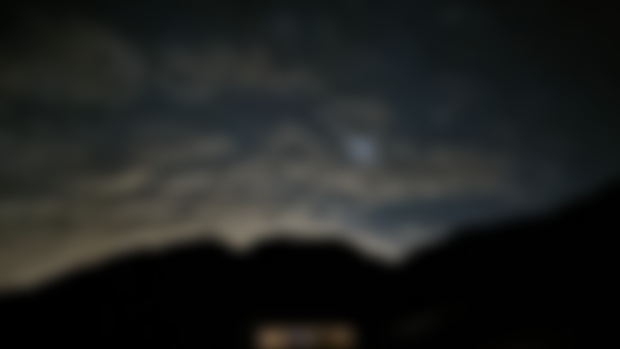 Night sky with moon about to rise above the mountain and our house. 