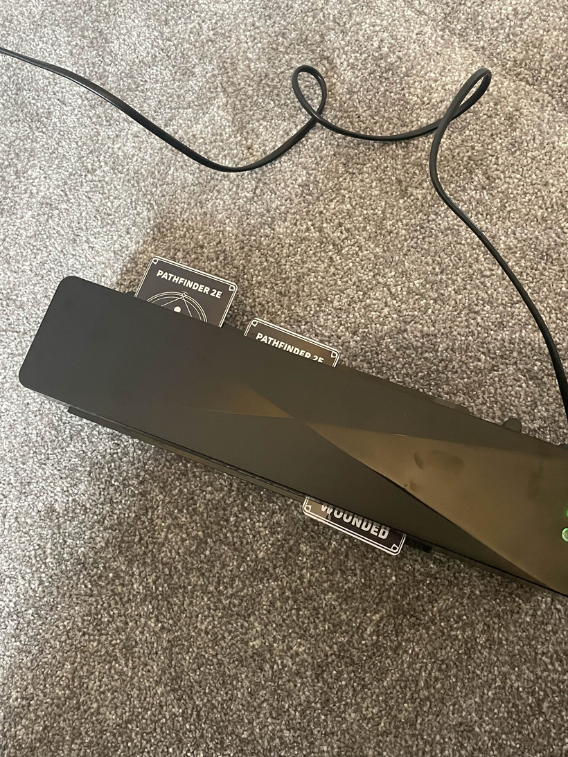 Stack of cut cards being fed through a laminator for a second pass