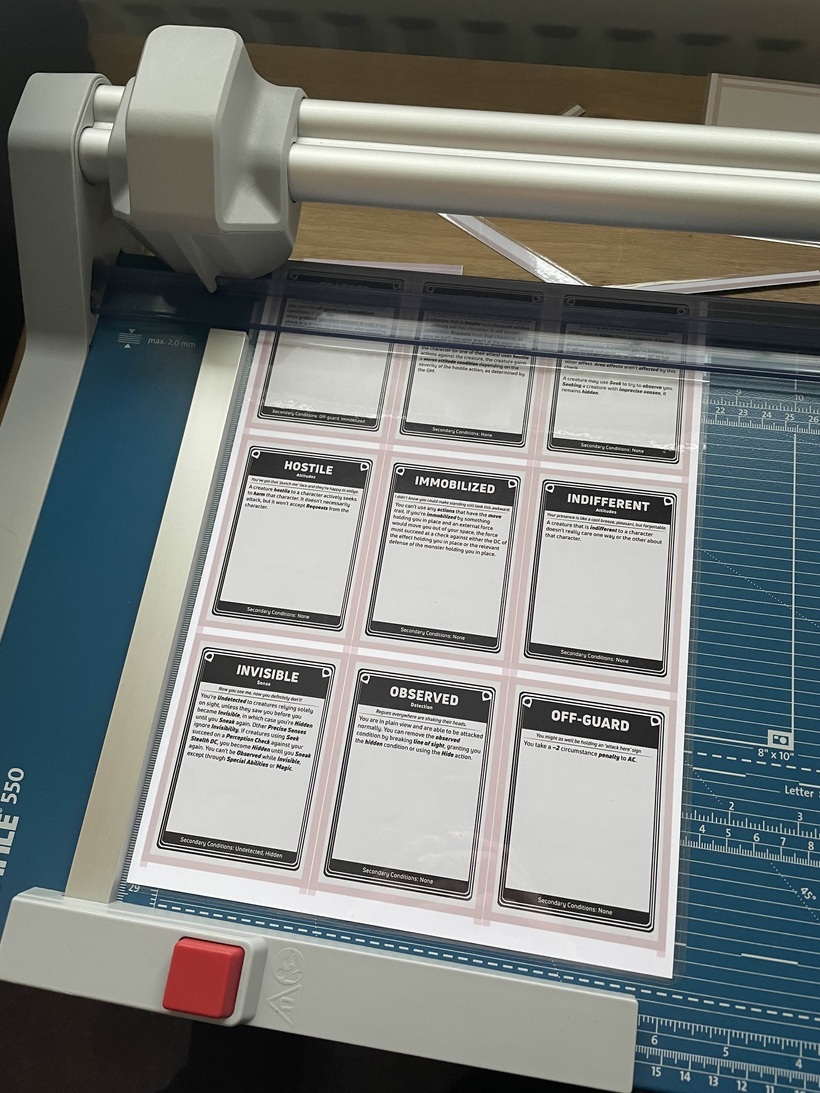 Rotary trimmer cutting laminated cards with a corner rounder nearby