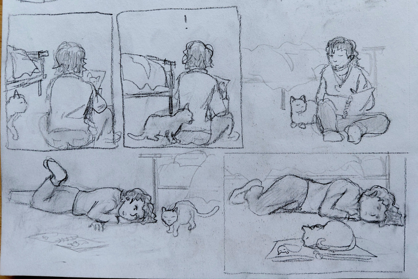 She draws in her sketchbook to pass the time and when she puts the pad down the cat comes out and sits on it