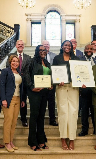Basketball player Aliyah Boston is depicted with her mother, Cleone, and Massachusetts Gov. Maura Healey in an official photo taken on Aliyah Boston Day: July 14, 2015.