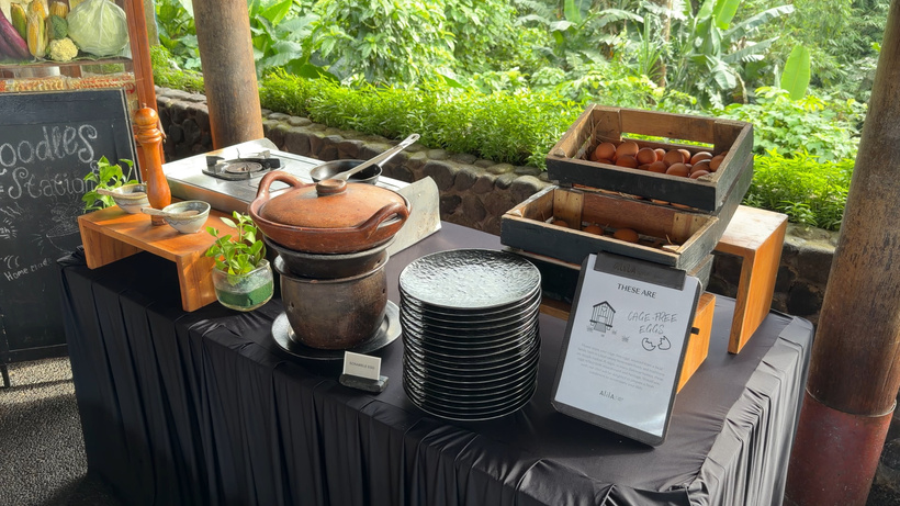 Breakfast buffet station at Plantation with a clay pot, crates of cage free eggs, stacked plates and a chalkboard sign