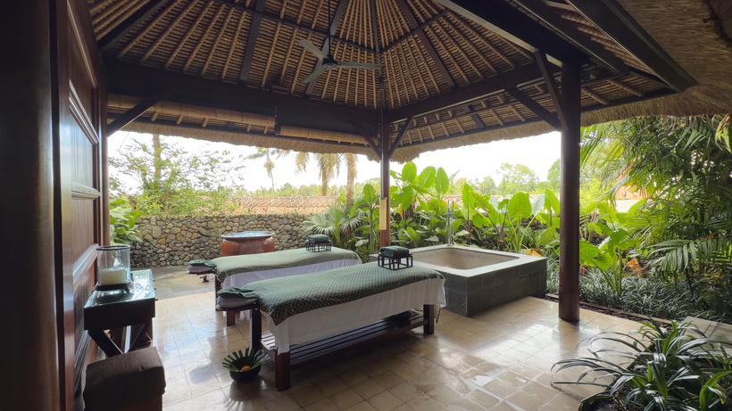 Open-air treatment pavilion at Spa Alila with two massage beds and a stone bath overlooking greenery