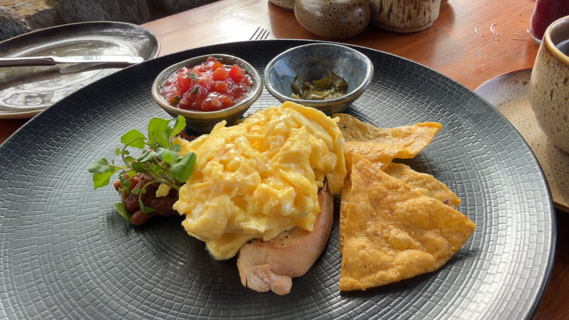 Plate of Ranchero scrambled eggs with a tomato salsa and small side dishes at Plantation restaurant, Alila Ubud