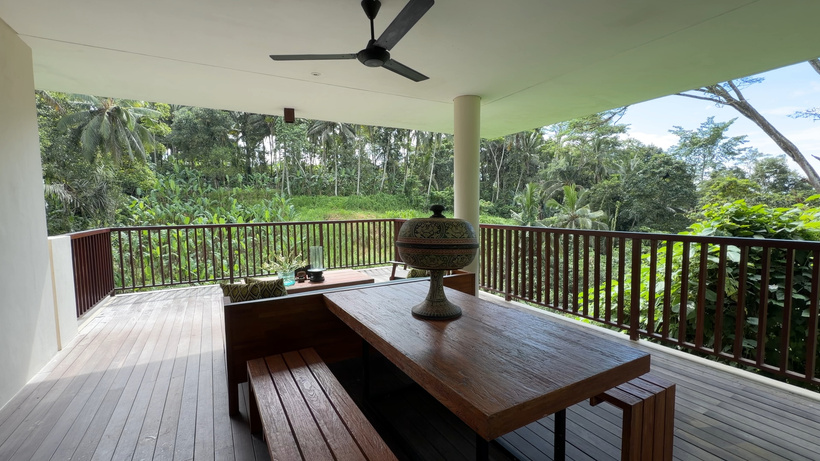 Forest View Villa terrace at Alila Ubud with a wooden dining table, ceiling fan and railing overlooking the jungle valley